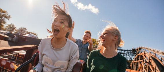 two girls laughing and screaming joyfully on a rollercoaster